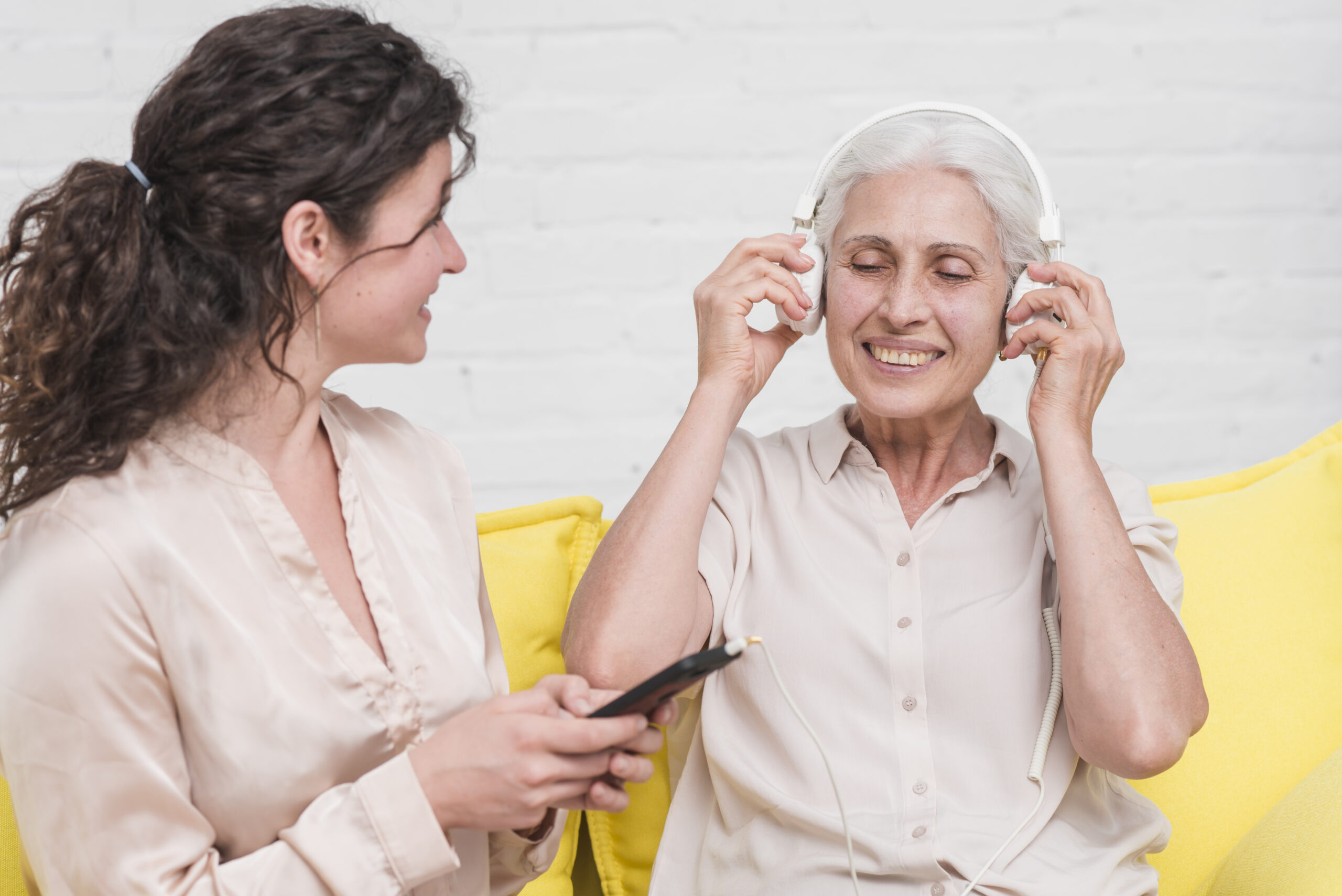 http://daughter-holding-mobile-phone-while-her-mother-listening-music-headphone