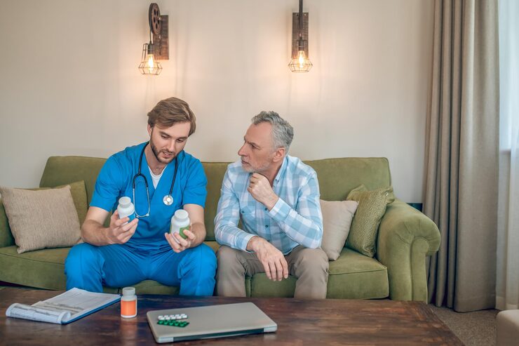 http://front-view-young-doctor-with-plastic-vitamin-bottles-his-hands-talking-mature-man_259150-57390