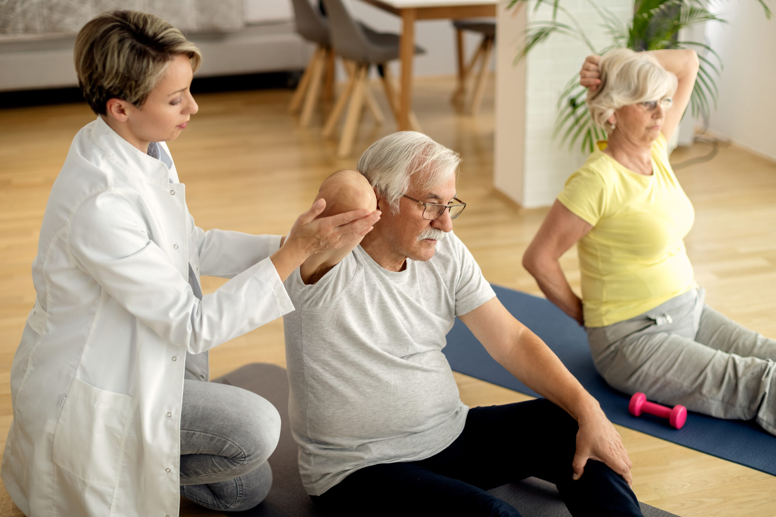 http://Physical%20therapist%20assisting%20mature%20couple%20with%20exercises%20at%20hom