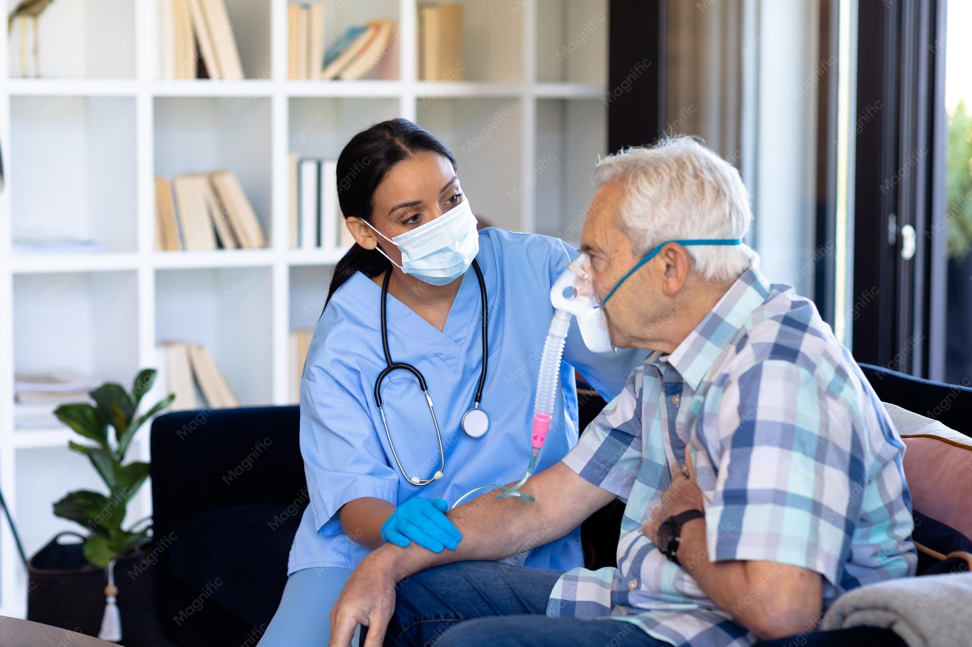 biracial-female-doctor-examining-caucasian-senior-man-wearing-oxygen-mask-sitting-sofa-home_13339-332800 (2)